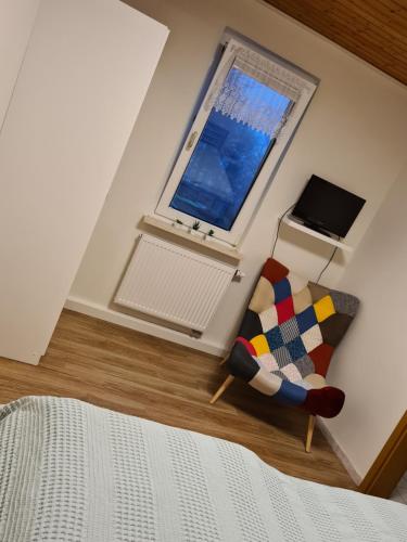 a bedroom with a couch and a window at Schönes Doppelzimmer mit Küche und Badezimmer in Elgersburg
