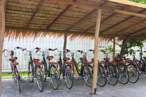 una fila de bicicletas estacionadas bajo un techo de madera en Baan Pila en Luang Prabang