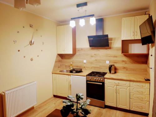 uma cozinha com armários brancos e um forno com placa de fogão em ChillHouse 2 em Mrągowo