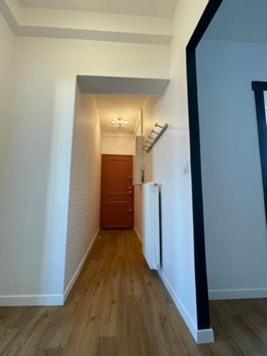 una stanza vuota con corridoio e frigorifero di Smart Inn Melun Centre- Appartement 2 chambres a Melun