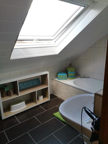 a bathroom with a bath tub and a skylight at Eifelferienkurth in Buir