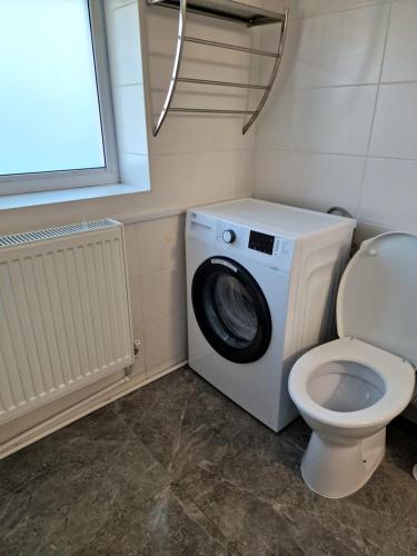 a bathroom with a washing machine and a toilet at Stay Inn Rediu in Iaşi