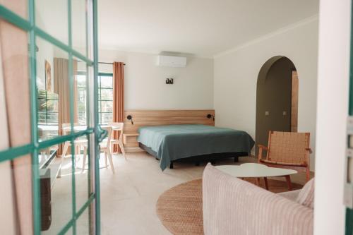 um quarto com uma cama, uma mesa e cadeiras em Casa Velha Apartments - 4stars - Adults only em Albufeira