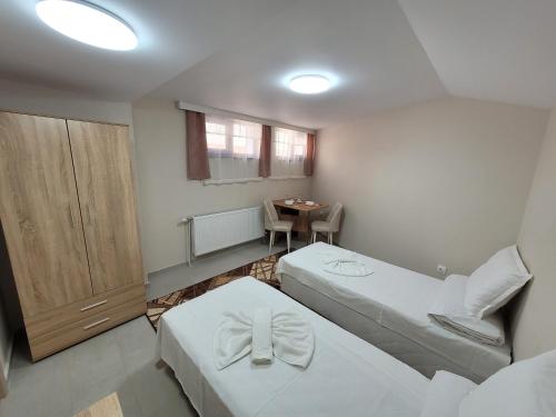 a small room with two beds and a table at Китанови- стаи за гости in Sliven