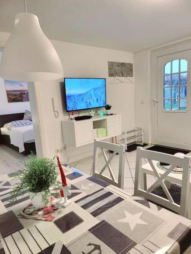 a living room with a television and a living room with a table at Haus Vineta in Barth