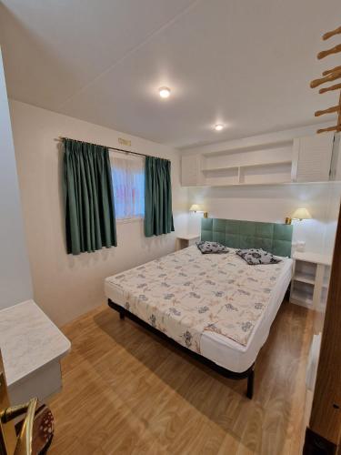 - une chambre avec un lit et des rideaux verts dans l'établissement Gard les Dolmens, à Méjannes-le-Clap