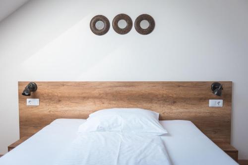 a bedroom with a bed with two clocks on the wall at Magtár Villa in Bóly
