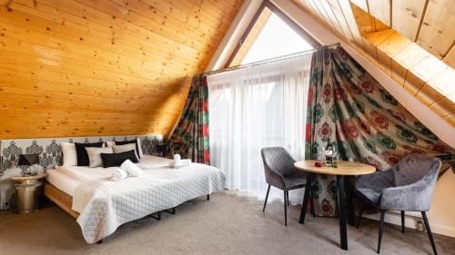1 dormitorio con cama, mesa y ventana en Aparthotel Delta Zakopane, en Zakopane