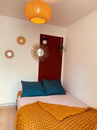 une chambre avec un lit avec des oreillers bleus et un miroir dans l'établissement Tiny81 cozy city break appartment, à Clichy