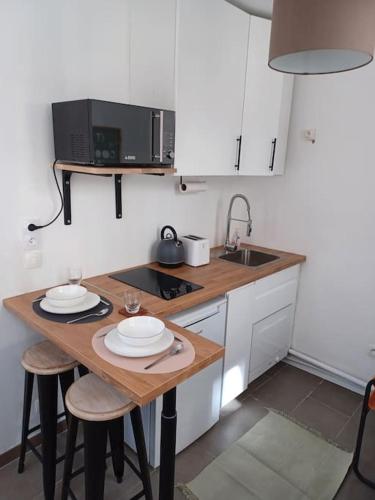 une petite cuisine avec une table et un micro-ondes dans l'établissement Tiny81 cozy city break appartment, à Clichy