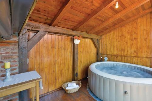 ein Badezimmer mit einer großen Badewanne in einer Holzdecke in der Unterkunft Bakina kuća (Grandma's house) in Sveti Ivan Žabno