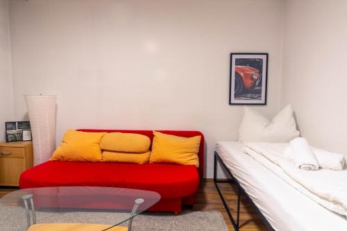 萊比錫的住宿－Balkon, Waschmaschine, TV, Einzelbetten, nahe Völkerschlachtsdenkmal，客厅配有红色和黄色的沙发
