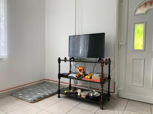 einen Fernseher auf einem Regal neben einer Tür in der Unterkunft Fecskefészek Vendégház in Siófok