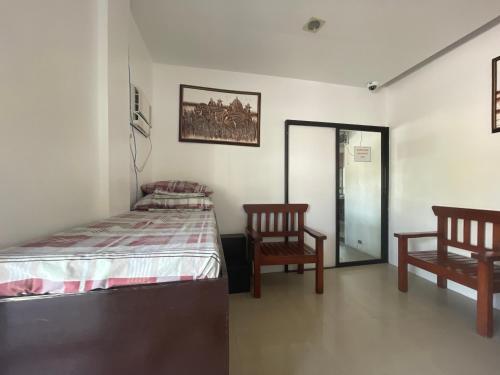- une chambre avec un lit et deux chaises dans l'établissement Poracay Resort powered by Cocotel, à Porac