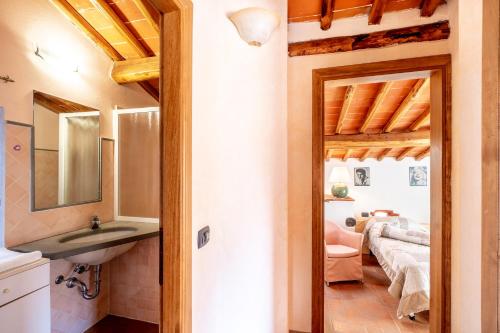 a bathroom with a sink and a mirror and a bedroom at Agriturismo Podere Luisa in Montevarchi