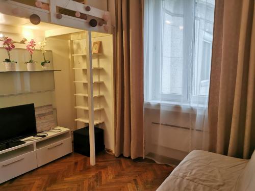 1 dormitorio con cama, ventana y TV en Liberty Bridge Zenta en Budapest