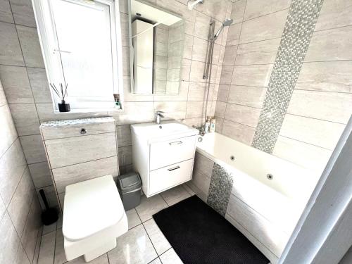 a bathroom with a toilet and a sink and a tub at Beautiful Double Room for One Person in Hither Green