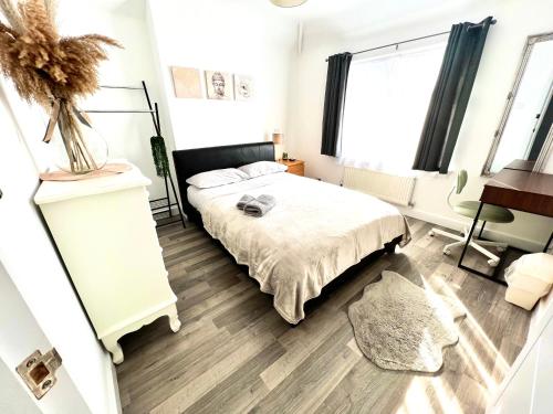 a bedroom with a bed and a desk and window at Beautiful Double Room for One Person in Bromley