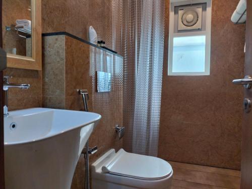 ein Bad mit einem WC und einem Waschbecken in der Unterkunft Hotel Grand Alleppey in Alappuzha