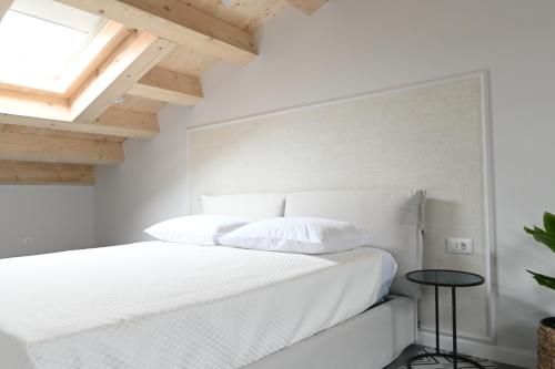 a white bedroom with a bed and a skylight at Borelli Palace & Borelli Blue in Zadar