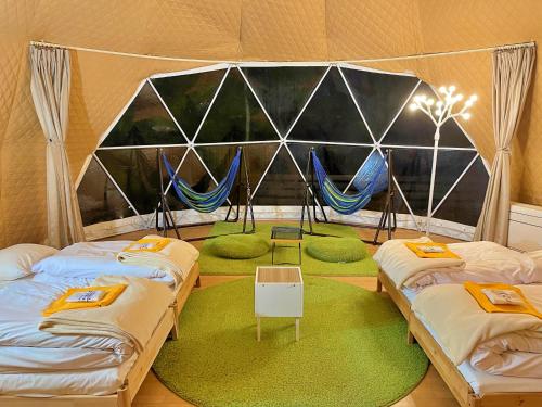 a room with three beds in a tent at glampark Morinoyado Nagano in Urugi