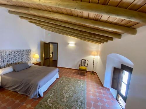 ein Schlafzimmer mit einem Bett und einer Holzdecke in der Unterkunft Casa del Marqués in Fregenal de la Sierra