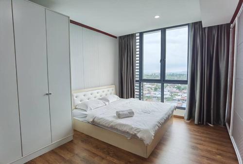 1 dormitorio con cama y ventana grande en Jeff and Ricky Homestay 39 @ Vivacity (Huge Unit) en Kampong Tabuan