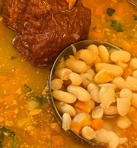 a bowl of beans and carrots in a soup at Pensiunea Deceneu in Slănic