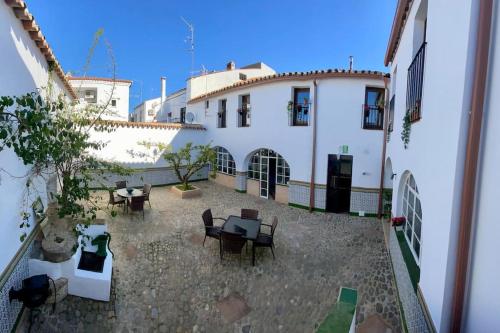 a courtyard with tables and chairs in front of a building at Casa del Marqués in Fregenal de la Sierra