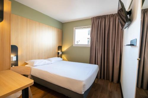 a hotel room with a bed and a window at B&B HOTEL Bordeaux Mérignac Aéroport in Mérignac
