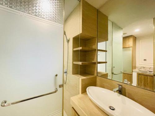 ein Badezimmer mit Waschbecken und Spiegel in der Unterkunft Deluxe Room @ ArtDeco Luxury Hotel & Residence By Parker House in Bandung