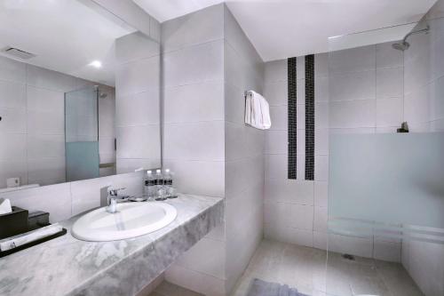 a white bathroom with a sink and a shower at Neo+ Penang in George Town