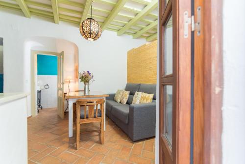 un soggiorno con un divano e un tavolo di Casa La Favorita a Vejer de la Frontera