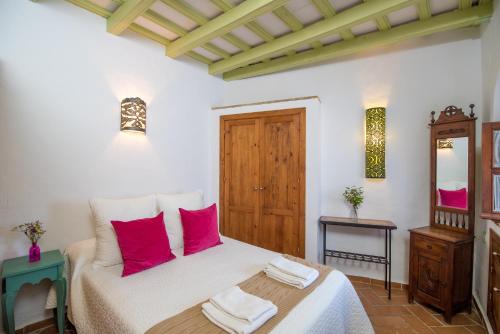 una camera da letto con un letto con cuscini rossi di Casa La Favorita a Vejer de la Frontera