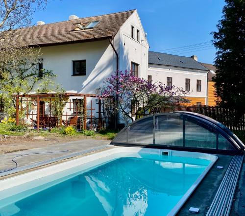 a swimming pool with a car parked next to a house at Chalupa pod Milesovkou in Milešov