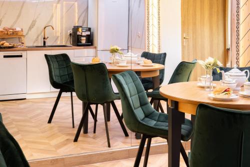 a dining room with tables and green chairs at GORSKI RESORT Lux Apartments Jacuzzi & Sauna in Poronin