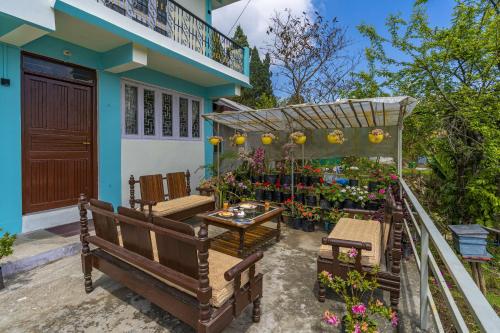 a patio with a table and chairs and flowers at Zostel Homes Pedong, Kalimpong in Kalimpong