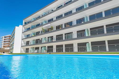 a building with a large swimming pool in front of it at Monte Residence Beach e Pool in Portimão