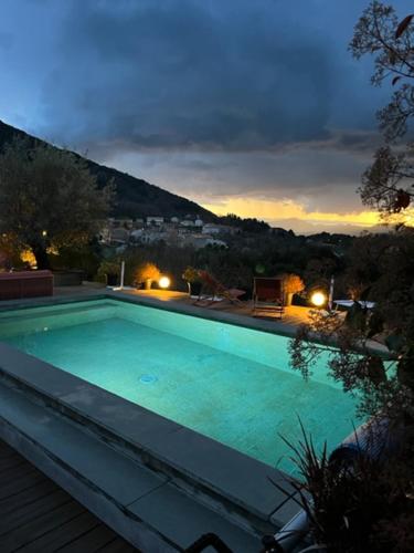 a swimming pool at night with a view of a city at Casa Santa Lucia in Bocognano