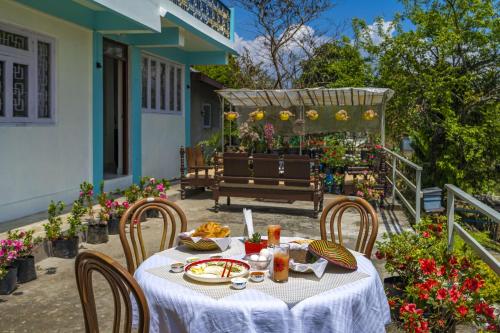 a table with a white table cloth on a patio at Zostel Homes Pedong, Kalimpong in Kalimpong
