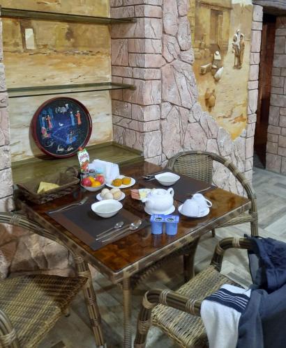 einen Tisch mit einem Tee-Set und zwei Stühlen in der Unterkunft Pan Asiat in Taschkent
