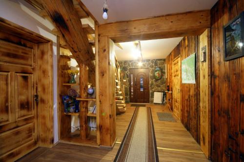 a hallway of a house with wooden walls and wooden floors at Pod Słowackim in Szczawnica