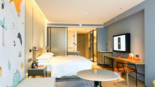 a bedroom with a bed and a desk and a table at Four Points by Sheraton Chongqing, Yongchuan in Yongchuan