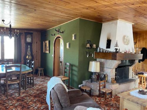 a living room with a fireplace and a table at Sirolane, chalet au bord des pistes au Sauze in Enchastrayes