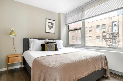 a bedroom with a bed and a large window at Gold Coast 2BR w Gym Roof nr Water Tower CHI-389 in Chicago
