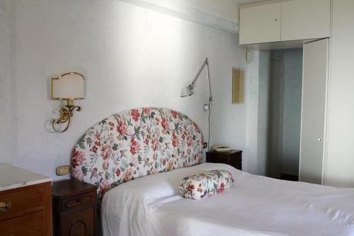 a bedroom with a bed with a floral headboard at B&B Le Palme in Ameglia