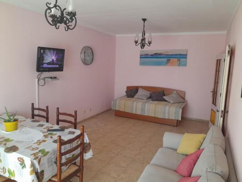 a living room with a couch and a bed at Residence 1000 Roses in Moncarapacho