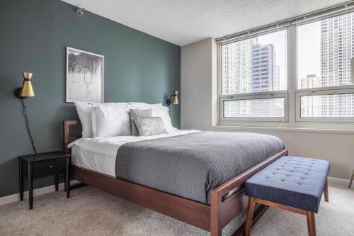 a bedroom with a bed and two windows at River N 2BR w Gym WD nr Magnificent Mile CHI-160 in Chicago
