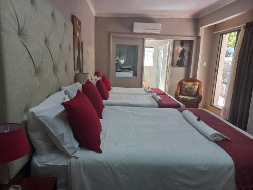 a bedroom with two large beds with red pillows at Lavender Lane in Ladysmith