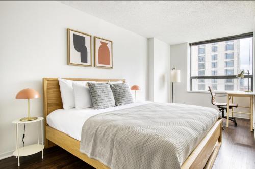 a bedroom with a bed and a desk and a window at Streeterville 1BR w Gym Pool nr Navy Pier CHI-411 in Chicago